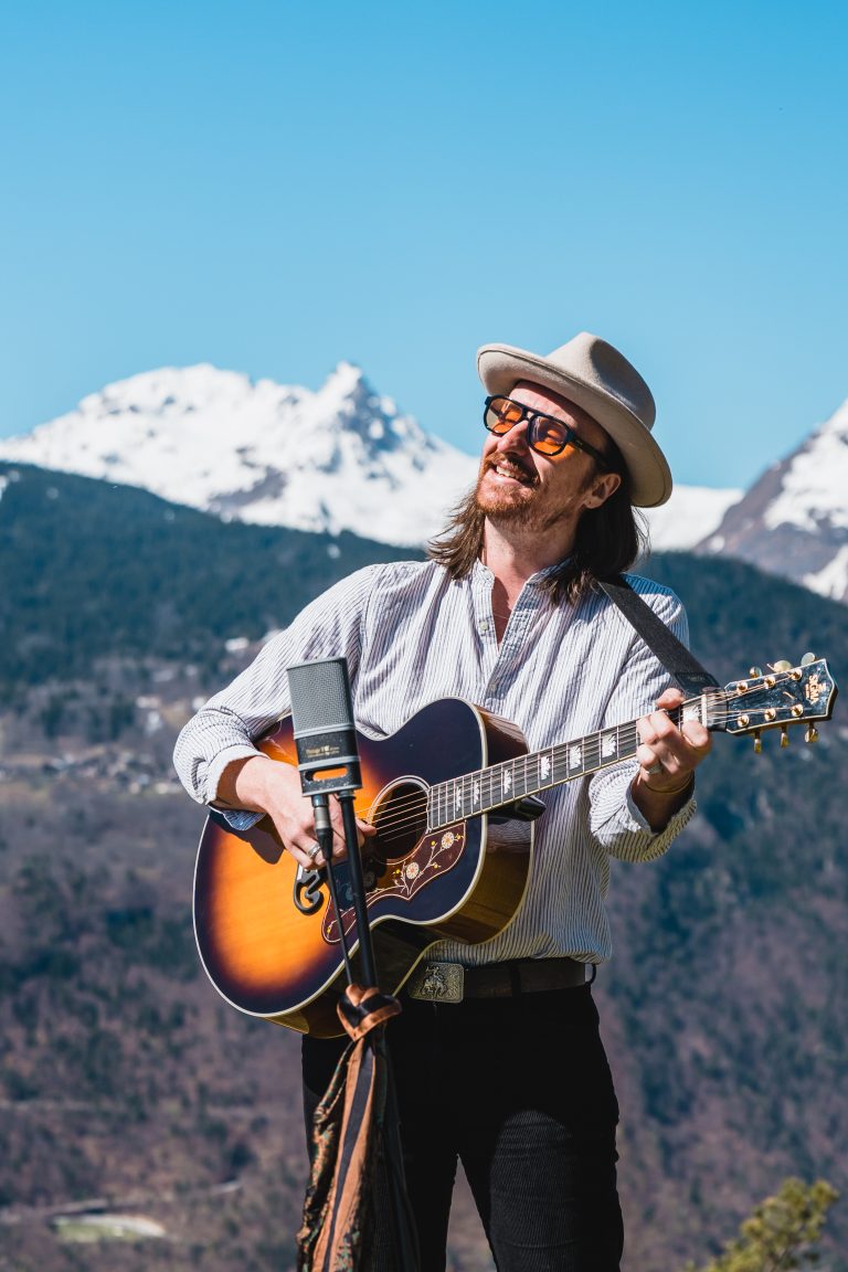 Connor Mackenzie acoustic guitarist with stomp-box and harmonica for ski resort entertainment