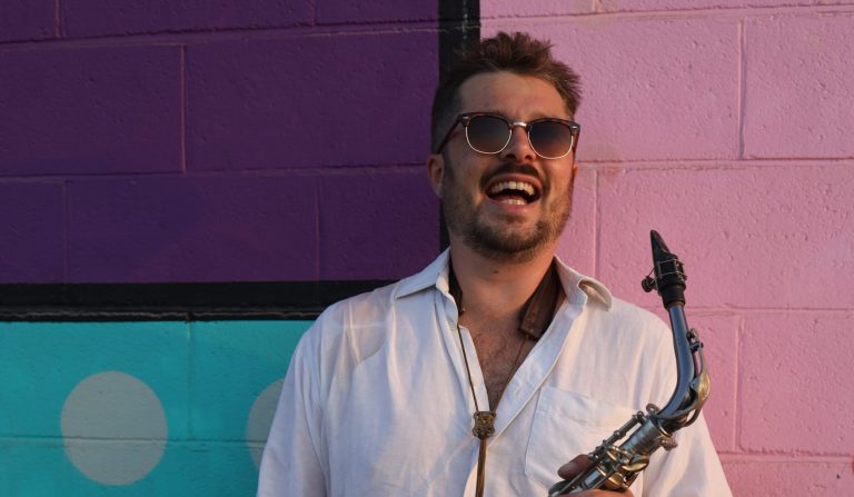 Hamish, known as Tasty Sax, holding his saxophone